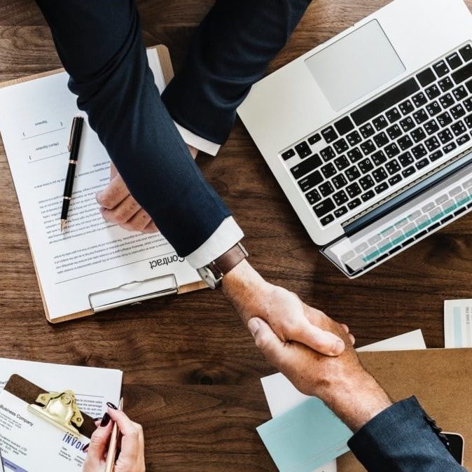 Un grand arbre avec un tronc imposant et des branches étendues, soleil rayonnant à travers les feuilles.